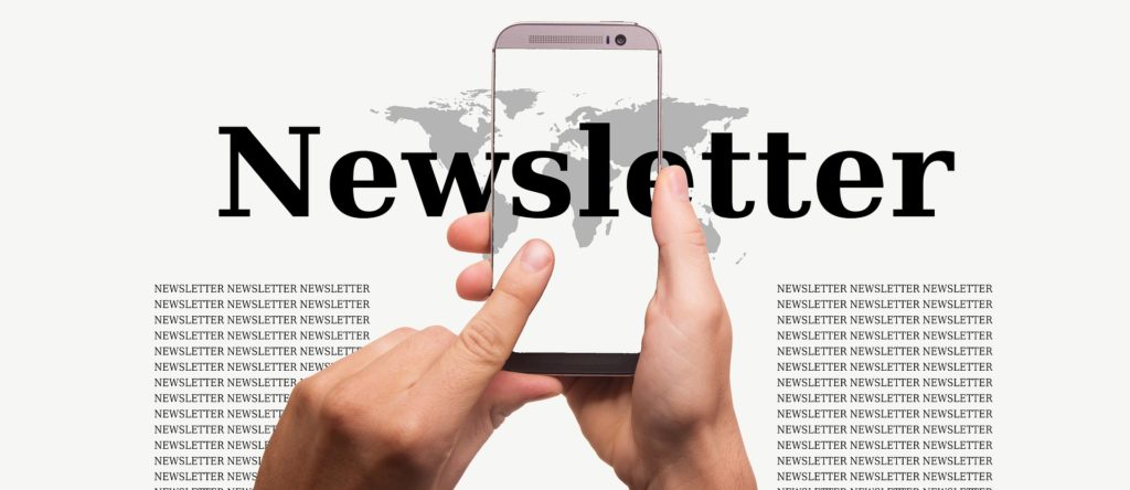 Picture of the words Newsletter with person holding and clicking cell phone