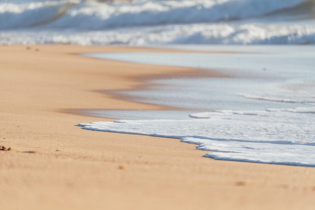 A picture of a beach with the tide retreating. 