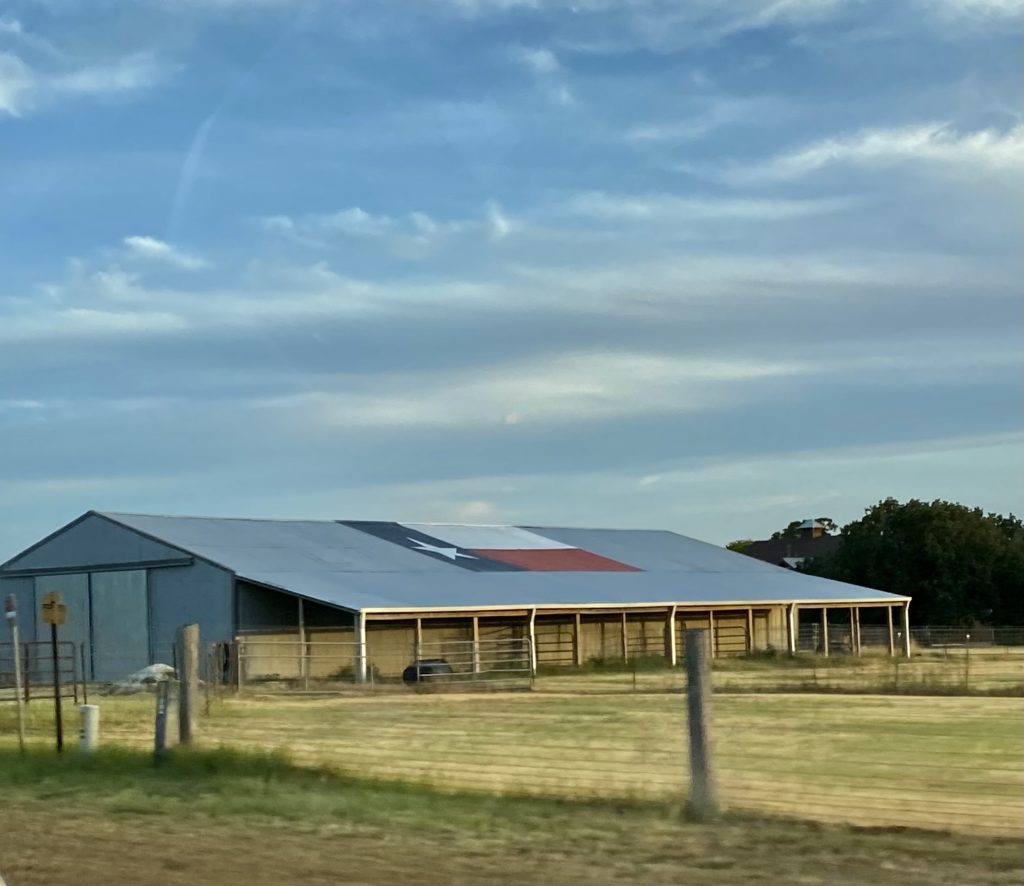 Picture of a barn with the Texas State flag painted on it. 